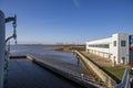 A shot of Mobile Bay with shipping cranes and shipping containers, an airplane hangar and the USS Alabama Battleship