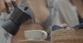 Shot of mocha coffee pot, woman pours coffee into the coffee cup, outdoor