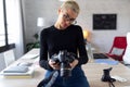 Modern young entrepreneur woman reviewing her last photographs in the camera while sitting in the office Royalty Free Stock Photo