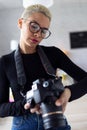 Modern young entrepreneur woman reviewing her last photographs in the camera while sitting in the office Royalty Free Stock Photo