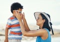 Sunglasses are really helpful for protecting your eyes. Shot of a mother applying sunscreen to her son at the beach. Royalty Free Stock Photo