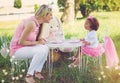 Imagination is their favourite toy. Shot of a mother and her cute little girl having a tea party on the lawn outside. Royalty Free Stock Photo