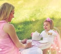 Let me pour you a cuppa. Shot of a mother and her cute little girl having a tea party on the lawn outside. Royalty Free Stock Photo