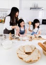 Shot of a mother and two daughter make together for bake in the kitchen