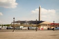 Shot in motion: cars and motorcycles drive along the Place de la Concorde amid the stands of the Bastille Day and the Luxor Royalty Free Stock Photo