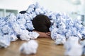 Overwhelmed in the workplace. Shot of an office worker passed out under a pile of crumpled up paperwork. Royalty Free Stock Photo