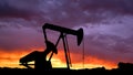 Shot of oilfield crane over sunset sky background. Large drilling rig tower head extracting crude oil from the soil. Royalty Free Stock Photo