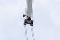 Shot of an old, rusty port crane preparing to lift cargo in ship on overcast sky background. Royalty Free Stock Photo