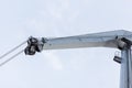 Shot of an old, rusty port crane preparing to lift cargo in ship on overcast sky background. Royalty Free Stock Photo