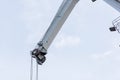 Shot of an old, rusty port crane preparing to lift cargo in ship on overcast sky background. Royalty Free Stock Photo