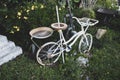 Shot of an old white bike used as decor in the garden Royalty Free Stock Photo