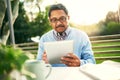 Staying socially connected in his retirement. Shot of an older man using a digital tablet while having his breakfast Royalty Free Stock Photo