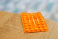 Shot of an orange pile of medical tablets on a wooden surfac