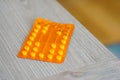 Shot of an orange pile of medical tablets on a wooden surface