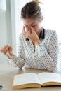 Overworked businesswoman suffering from headache and thinking how to end work in the office. Royalty Free Stock Photo