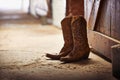 Another day done. Shot of a pair of cowboy boots in a barn. Royalty Free Stock Photo