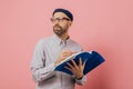 Shot of pensive unshaven man concentrated aside, thinks about what to write. Handsome male architect holds book and crayon, Royalty Free Stock Photo