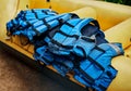 These guys can save your life. Shot of a pile of river rafting life jackets lying on top of a rubber river rafting boat