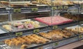 Shot of pink sheet cake with sprinkles and other Mexican pastries in a display case