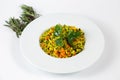 Shot of a a plate of Couscous with vegetables on a white table decorated with green plants