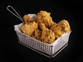 Shot of a plate full of fried chicken drumsticks on a black background