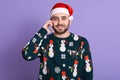 Shot of positive Christmas man talking via modern smart phone. Bearded man in Santa hat speaking on cell phon, handsome male Royalty Free Stock Photo