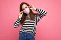 Shot of positive young attractive woman wearing mediacal face mask isolated over background wall. Protection against