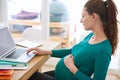 Online tips for first-time mothers. Shot of a pregnant woman using her laptop at home. Royalty Free Stock Photo