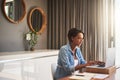 Managing pregnancy and her monthly bills. Shot of a pregnant young woman using a laptop while working from home. Royalty Free Stock Photo