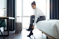 Pretty businesswoman taking off high heels shoes after work at her hotel room Royalty Free Stock Photo