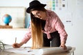 Pretty young architect woman working on a blueprints in the office. Royalty Free Stock Photo
