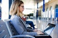 Pretty young business woman using her laptop in the train station. Royalty Free Stock Photo