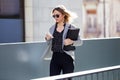 Pretty young business woman using her mobile phone in the street. Royalty Free Stock Photo