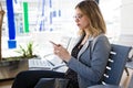 Pretty young business woman using her mobile phone in the train station. Royalty Free Stock Photo