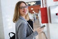 Pretty young business woman using her mobile phone in the train station. Royalty Free Stock Photo