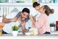 Pretty young mother kissing her baby son while having fun with father in the kitchen at home Royalty Free Stock Photo