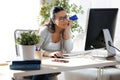 Pretty young woman holding blue credit card for shopping online with computer at home Royalty Free Stock Photo