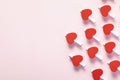 Shot of red hearts on clothespins arranged on the part of the pink background