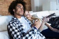 Relaxed young couple changing channels with the remote control while watching TV on the sofa at home Royalty Free Stock Photo