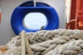 A shot of a rope with a blue ship window on the background Royalty Free Stock Photo