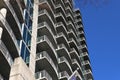 A shot of rows of balconies with gray metal rails on the side of a building with blue sky in Atlanta