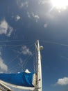 Sailboat sail detail over blue sky with bright sun