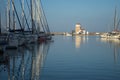 Shot of sailboats in the harbor on the background of a lighthouse