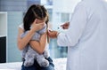 Is it done yet. Shot of a scared little girl getting a vaccination in a hospital. Royalty Free Stock Photo