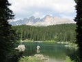 Shot of the scenic Carezza lake in Italy on the forest and Latemar mountains backgroun