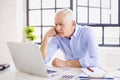 Shot of senior businessman having video call while sitting behind his compute in the office Royalty Free Stock Photo