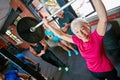 It doesnt get easier, you get stronger. Shot of a senior woman lifting weights while a group of people in the background Royalty Free Stock Photo