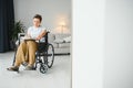 Shot of a senior woman sitting in a wheelchair and reading book at home Royalty Free Stock Photo