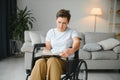 Shot of a senior woman sitting in a wheelchair and reading book at home Royalty Free Stock Photo