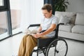 Shot of a senior woman sitting in a wheelchair and reading book at home Royalty Free Stock Photo